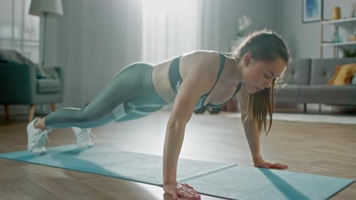 Woman doing push ups on a yoga mat
