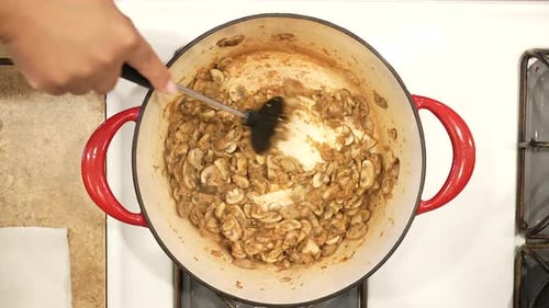 Sautéing organic mushrooms in a pot on the stove in preparation for making soup - overhead view WILD