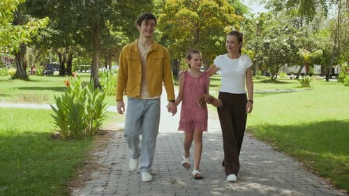 Daughter and Parents Walking along Trail in City Park