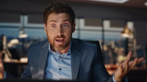 Businessman Talking At His Computer in Office Setting