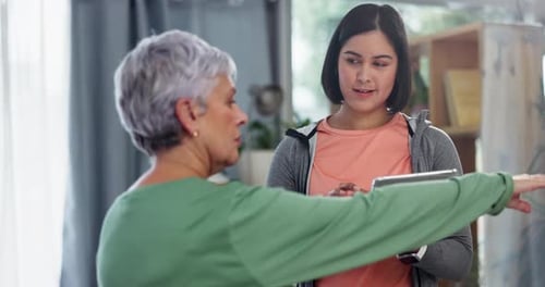 Women Talking and Using Tablet Indoors