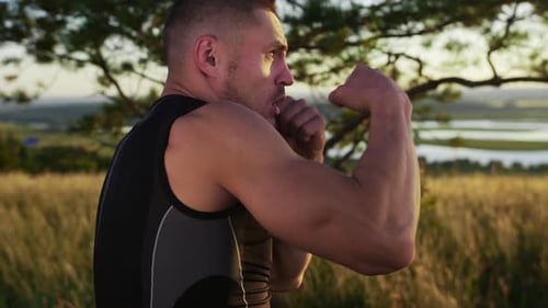 Handsome Muscular Man in Sportswear Boxing on the Field