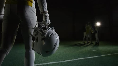 Male Gridiron Football Player Walking towards Teammates at Stadium