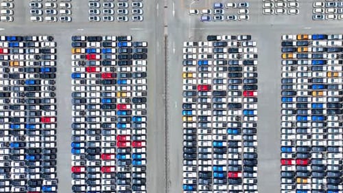 Aerial view of a car lot with neatly arranged vehicles. 4K.