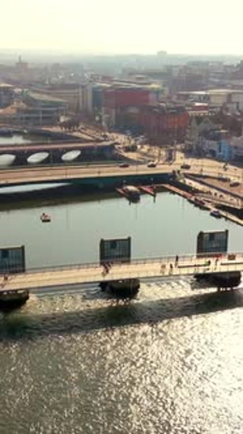 Rising 60FPS vertical social ratio aerial video of the River Lagan and Lagan Footbridge in Belfast
