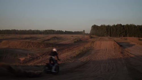 Motorcyclist Races on Sandy Dunes at Sunrise