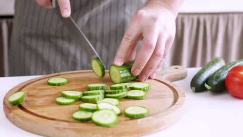 Cucumber Slices Being Cut in the Kitchen