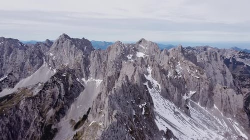 Aerial of steep rocky alpine mountain top peaks, epic landscape drone scenery view flying up
