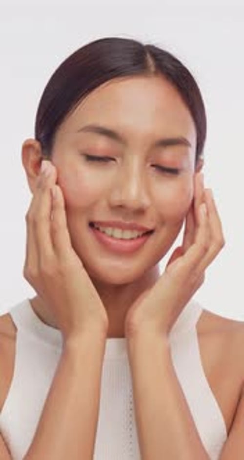 Smiling Woman Applying Gentle Pressure to Her Face