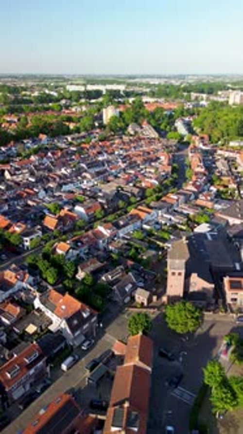 Aerial view of a residential town with rows of houses, narrow streets, and a central church tower.