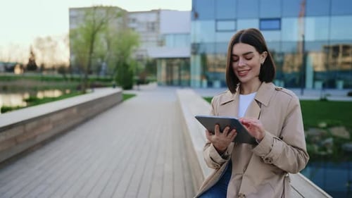Woman Using Tablet Outdoors in Urban Setting