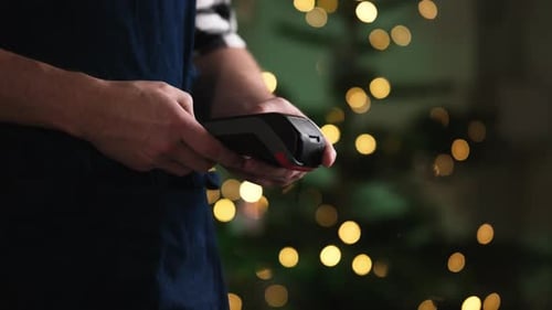 Man Using Mobile Payment Terminal at Christmas