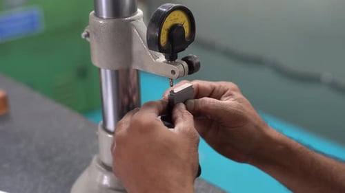 Homme asiatique mesurant la précision à l'aide d'un indicateur de niveau dans une usine indienne