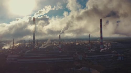 Power plant smokes. Aerial view of the power plant with smoking pipes and clouds passing by
