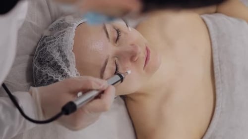 Middleaged Woman Receiving Micro Currents Facial Skin Treatment From Beautician in Spa Clinic