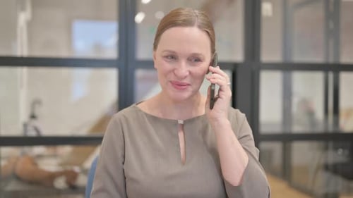 Woman Talking on Smartphone in Modern Office
