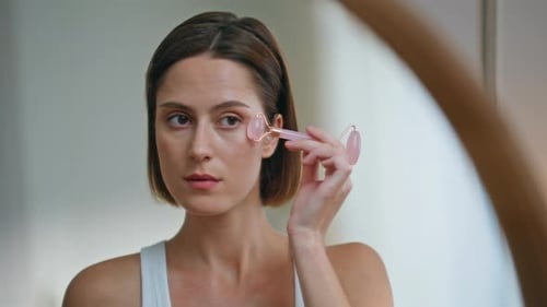 Woman Using Facial Roller at Home