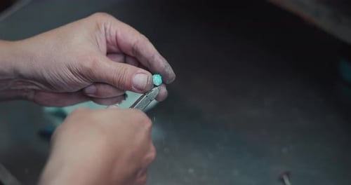 Jeweler Processes Splitted Crashed Blue Quartz Gem with Nippers at Jewlery Workshop