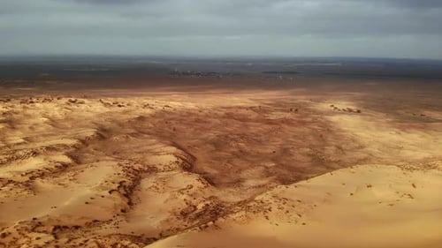 Aerial Perspective Illustrating Desolate Sandy Plains with Sparse Vegetation and Geological