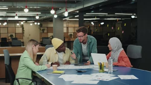 Team Discussing Business Blueprints in Modern Office