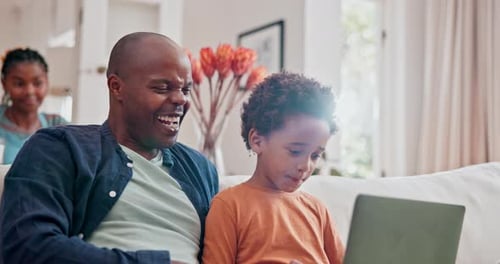 Father and Son Looking at Laptop at Home