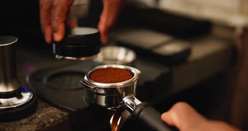 Machine, hands and barista with coffee tamper for preparing latte, espresso or cappuccino in cafe