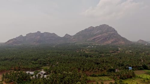 Aerial view of scenic landscape of rolling hills, lush green forests and agricultural fields under c