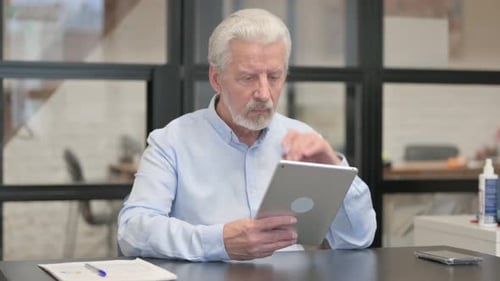 Old Businessman Using Digital Tablet in Office