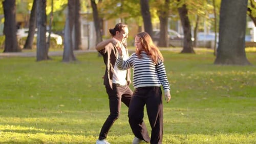 Young Asian Male Dancer and His Female Partner Dancing Together in a City Park on a Sunny Day and