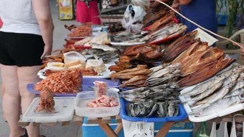 V29. Street trade in fish and seafood. The seller drives away flies and other insects from the fish.