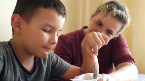 Loving Woman Feeding Child Inside Home