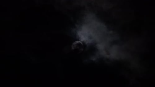 Clouds clearing over full moon in dark sky at night. Concept of haunted and spooky place.