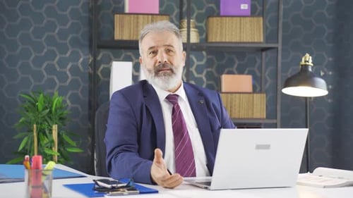 Senior Man Gesturing Frustrated at Computer in Office