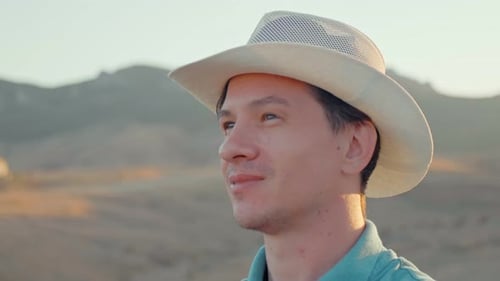 Man Smiles, Enjoying Desert Landscape View at Sunrise