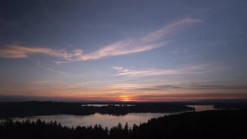Beautiful high clouds reflecting in dark waters, epic golden sunset, aerial hyper lapse