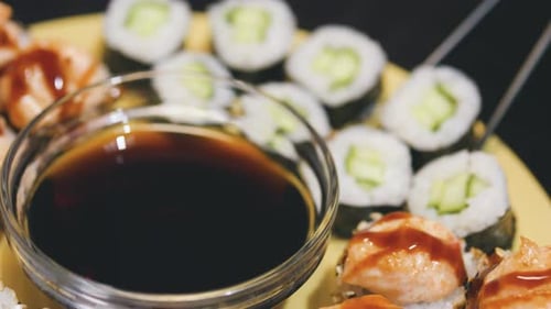 Taking a Sushi Roll with Black Chopsticks Close Up