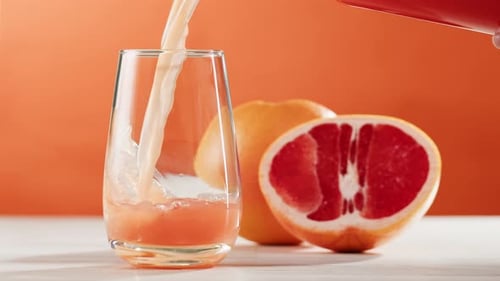Refreshing Grapefruit Juice Poured into Glass Still Life