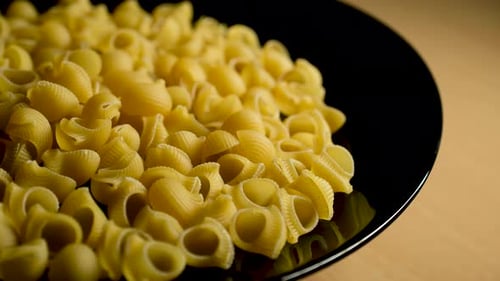 Raw Pasta on Rotating Black Plate – Close Up Food Shot