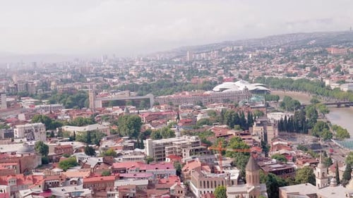 Camera panning over tbilisi showing kura river and bridge of peace