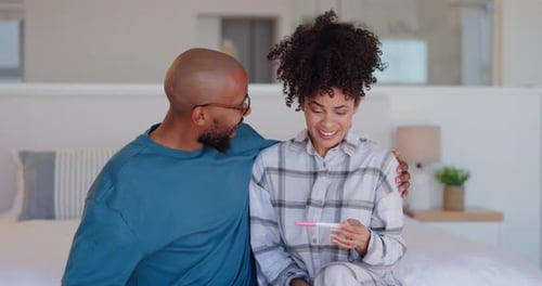 Couple Celebrate Positive Pregnancy Test on Bed