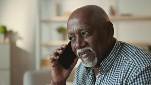 Elderly African American Man Talking on Smartphone at Home in Cozy Setting