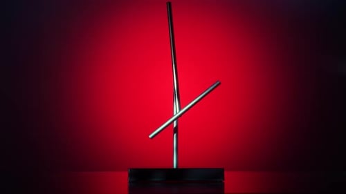 Magnetic Pendulum Balancing on Red Abstract Background