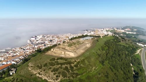 Aerial panning shot of medina sidonia with a view over the castillo de medina,the church of santa ma