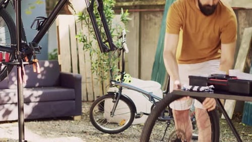 Homme entretenant un vélo démonté