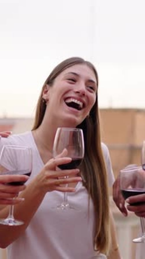 Young Adults Celebrate with Red Wine on Rooftop