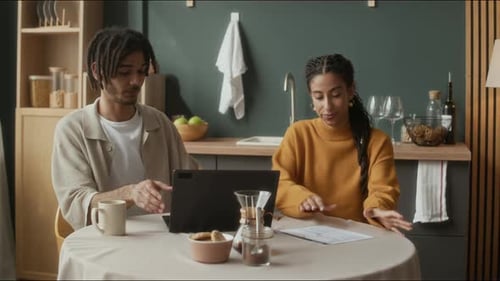 Couple Working Together on Laptop in Kitchen