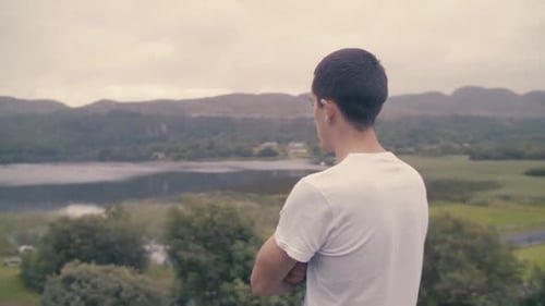 A young man overlooking a scenic lake view