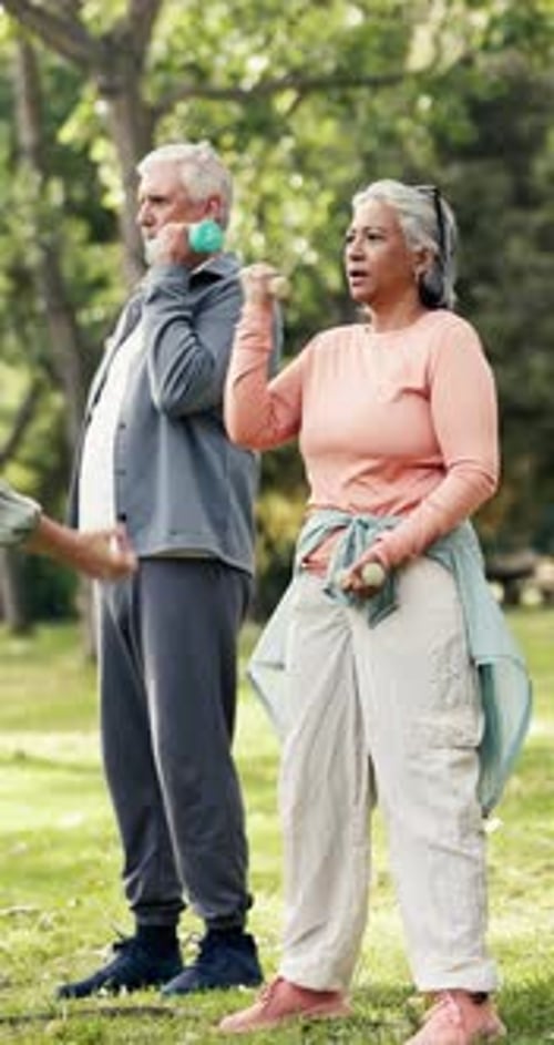 Senior people, weightlifting and dumbbells in park with coach for strength training or class