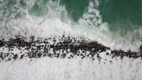 Aerial View of Waves Crashing on Rocky Coastline