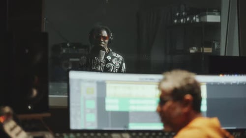 Sound Engineer and Black Singer Recording Song in Music Studio